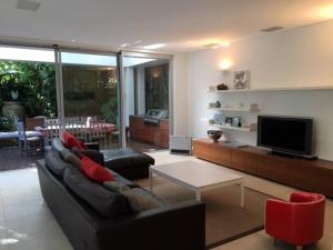 uma sala de estar com um sofá preto e uma televisão em Modern Queens Park Home near Bondi Junction, Bondi Beach & City em Sydney