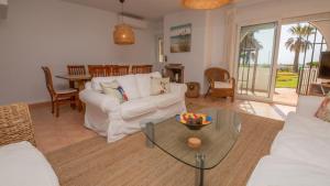 ein Wohnzimmer mit einer weißen Couch und einem Glastisch in der Unterkunft Marina de Casares 25 10 in Casares