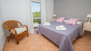 ein Schlafzimmer mit einem Bett und einem Stuhl und einem Fenster in der Unterkunft Marina de Casares 25 10 in Casares
