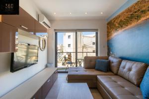 een woonkamer met een bank en een tafel bij High-End central APT with comfy BED & Super WIFI by 360 Estates in San Ġwann