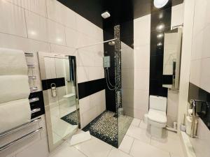 ein Bad mit einer Dusche und einem WC in der Unterkunft PHOENIX Boutique Apartments in Goole