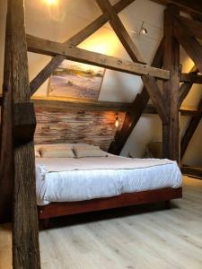 a large bed in a room with wooden beams at Les gites de Marie in Boulogne-sur-Mer