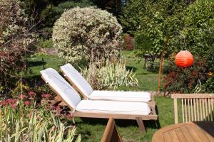 a pair of white chairs sitting in a garden at Superbe maison avec jardin magnifique! in Schiltigheim