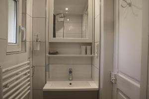 a white bathroom with a sink and a mirror at Superbe maison avec jardin magnifique! in Schiltigheim