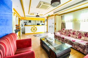 OYO 137 Marina Hotel في مسقط: غرفة معيشة مع أريكة وطاولة