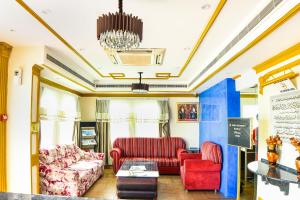 een woonkamer met rode meubels en een kroonluchter bij OYO 137 Marina Hotel in Muscat