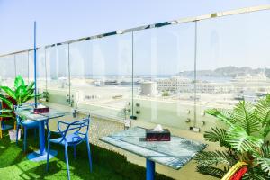 een balkon met twee blauwe stoelen en uitzicht op de luchthaven bij OYO 137 Marina Hotel in Muscat