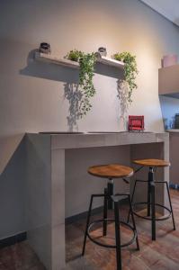 un mostrador con dos taburetes y una encimera con plantas en Beautiful apt downtown, Glyfada, en Atenas