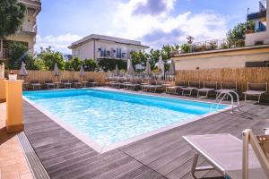 a swimming pool with chairs and umbrellas next to a building at Hotel Isabella Sorrento in Sorrento