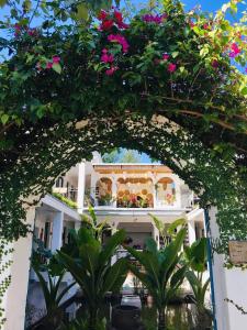 an archway in front of a building with flowers at Coto Island Beach Village Homestay in Dao Co To