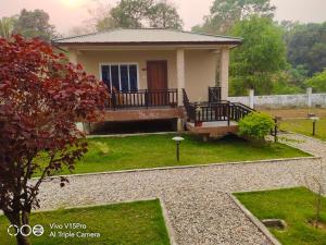 ein kleines Haus mit einer Veranda und einem Hof in der Unterkunft Hotel hornbill in Sauraha