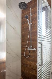 um chuveiro na casa de banho com uma parede de madeira em Villa Luz em Koumariés