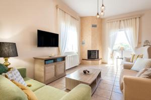 a living room with a couch and a tv at Villa Luz in Koumariés