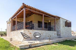 a house with two chairs in front of it at Villa Luz in Koumariés
