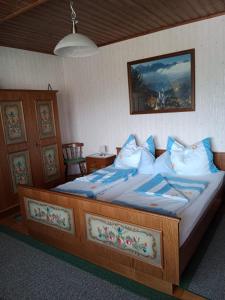 a bedroom with a large bed with blue and white pillows at Ferienwohnung Haus Gatternig in Seeboden