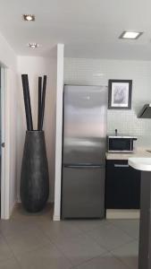 a kitchen with a stainless steel refrigerator and a vase at Casa de Playa Sol Y Mar in El Médano