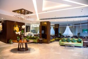 a lobby with green couches and a table at The Seven Hotel in Manama