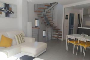 un soggiorno con un divano bianco e una scala di Casa de Playa Sol Y Mar a El Médano