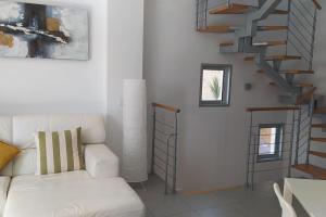un soggiorno con un divano bianco e una scala di Casa de Playa Sol Y Mar a El Médano Altre 53 foto