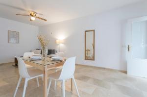 a dining room with a table and white chairs at Azvalia - Larga 112 in El Puerto de Santa María