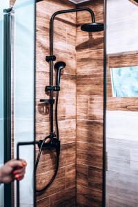 a shower with a hose attached to a wooden door at Dychnij Se in Szczyrk