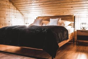 um quarto com uma cama grande e paredes de madeira em Dychnij Se em Szczyrk