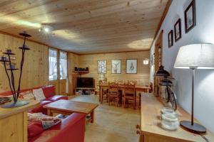 a living room with a red couch and a table at Lou Darbelots in La Giettaz