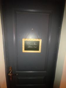 une porte noire avec un panneau sur celle-ci dans l'établissement CHAMBRE ZEN, à Mérignac