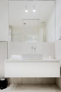 a white bathroom with a sink and a mirror at Touch&Go - via Gaetano Previati 38, Milano in Milan