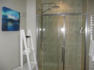 een badkamer met een douche en een glazen deur bij Beaconsview B&B in Brecon