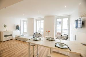 una sala de estar blanca con mesa y sillas en Quartier du château, superbe appartement avec parking, en Pau