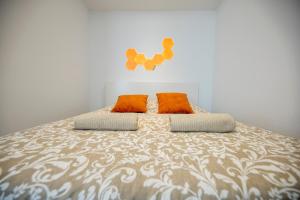 Una cama con dos almohadas naranjas encima. en Quartier du château, superbe appartement avec parking, en Pau