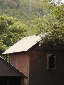 a barn with a window and trees in the background at Sabie Gypsy's Backpackers in Sabie