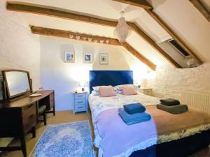 a bedroom with a bed and a desk and a mirror at The Stables in Fowey