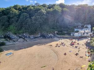 a group of people on a beach near a mountain at The Stables in Fowey
