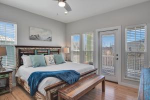 1 dormitorio con 1 cama con banco y ventanas en Nauti Beach, en Port Aransas