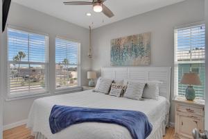 Un dormitorio con una cama y dos ventanas. en Nauti Beach, en Port Aransas