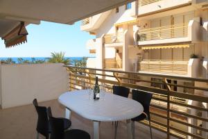 a table on a balcony with a bottle of wine at UHC Novelty Apartments in Salou