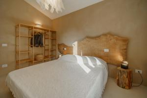Schlafzimmer mit einem großen Bett mit einem Kopfteil aus Holz in der Unterkunft Villa Elicriso Charme e Nature-Goelba in Portoferraio