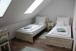 two beds in a room with a attic at Neidhardt Vendégház in Bóly