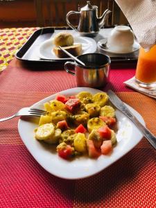a plate of food with potatoes and vegetables on a table at Bwindi Forest Lodge in Buhoma