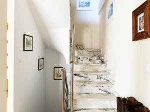 una escalera en una casa con suelo de mármol y paredes blancas en Casa Román III, en Gijón