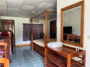 a bedroom with a bed with a mirror and a desk at The Creek Garden Resort Huainamrin ห้วยนำ้ริน in Mae Hong Son