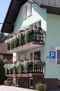 ein Gebäude mit einem Balkon mit Pflanzen in der Unterkunft Homestay Sreš in Mlaka pri Kranju