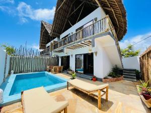 a villa with a swimming pool and a house at Chunga Changa in Matemwe