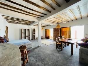 ein Schlafzimmer mit einem Bett und einem Tisch in einem Zimmer in der Unterkunft Chunga Changa in Matemwe