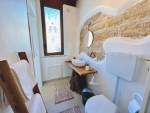 a bathroom with a white sink and a stone wall at da Mumminedda in Cinisi