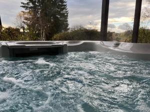 a jacuzzi tub with water in it at Hüttenresort Mare in Fichtelberg