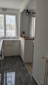 a kitchen with a counter and two windows at Cosy studio proche de la Défense Arena in La Garenne-Colombes