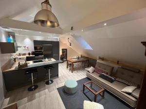 a living room with a couch and a kitchen at Appartement grand standing plein centre ville in Cauterets